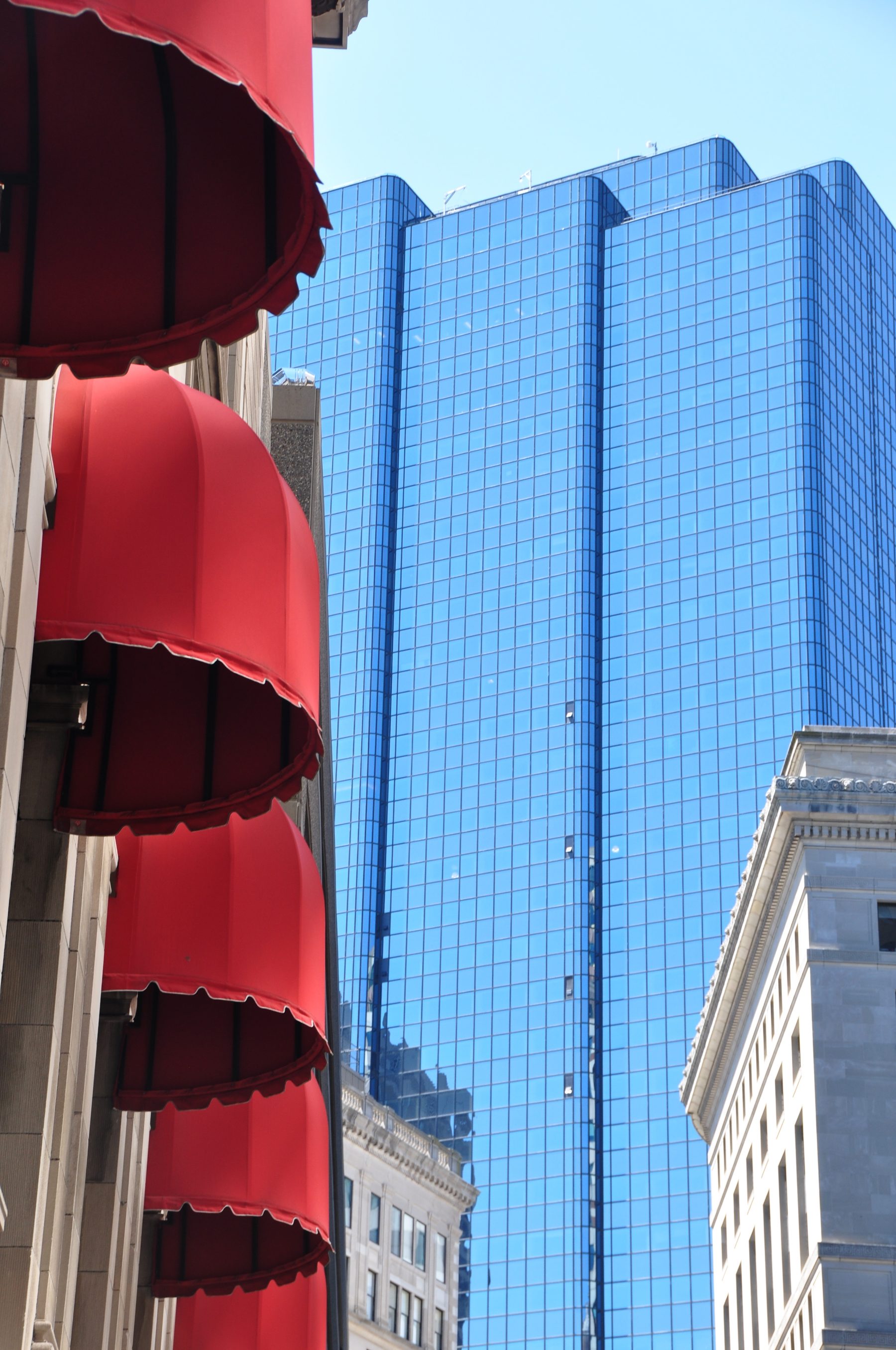 Red awnings against a glass tower in downtown Boston